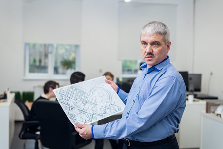 Close-up portrait of an old businessman showing his construction project to the camera.の写真素材