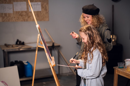 a young female Artist teaches a girl student to draw in the Studio. Private lessonの写真素材