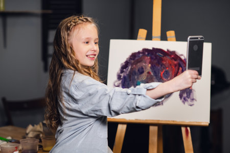 a young charming artist leads an online masterclass in drawing pictures in her workshopの写真素材