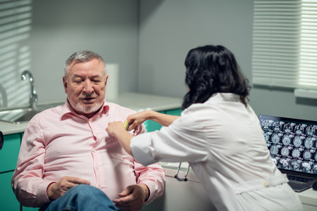 Old man offering money to his medical doctor. Bribe, corruption concept. A young female doctor refusing to take the money from an old man, she puts it back into the chest pocket of his shirt.の写真素材