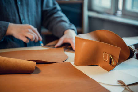 The workflow of creating exclusive leather shoes by a young craftsman in a shoe workshop.