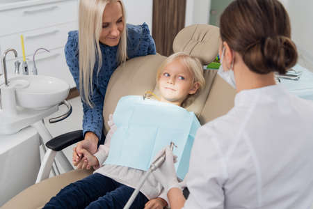 A child having a dental checkup with her motherの写真素材