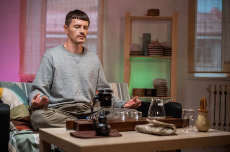 A master of traditional chinese tea drinking meditates at home while waiting for tea to be brewed.の写真素材