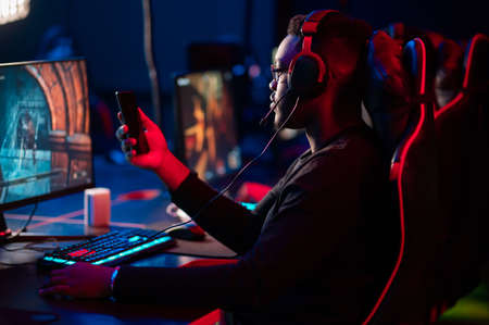 A black streamer leads a live broadcast on the phone from an esports tournamentの写真素材