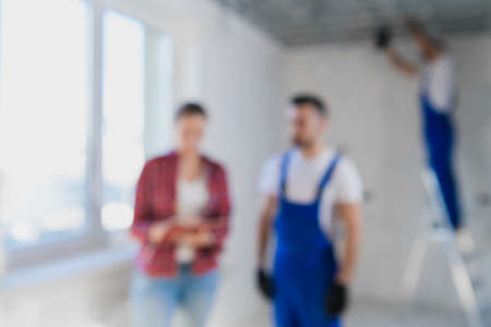 Blurred background of the supervisor checks the work of the workers in the apartment and writes a note.の写真素材