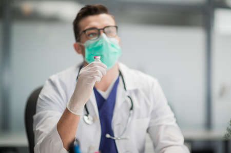 An experienced doctor with a stethoscope at the reception talks about the benefits of vaccinationの写真素材