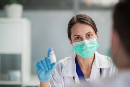 An attractive female doctor recommends a coronavirus vaccine to her patientの写真素材