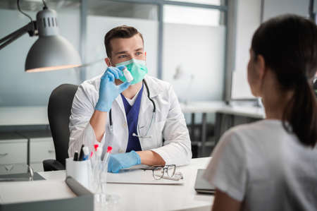An experienced therapist offers to get vaccinated with a new coronavirus vaccine to his patientの写真素材