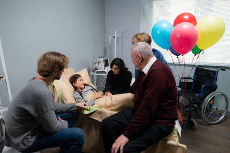 Relatives visiting a little girl in a hospital, she is recoveringの写真素材