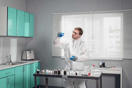 A young clinician studying a chemical element in a laboratoryの写真素材