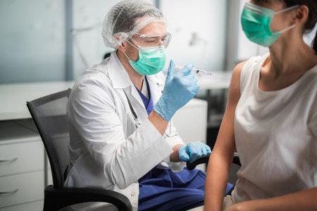 The covid-19 vaccine is injected into a young womans handの写真素材