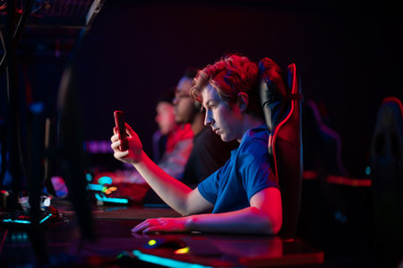 A young esports player records a video on his phone for his vlog from the training base of his team...