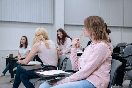 During a college lecture on mathematics, students go about their business, smile and get distractedの写真素材