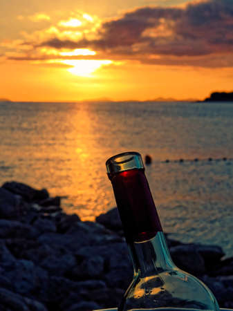 Bottle of wine with sunsetの写真素材