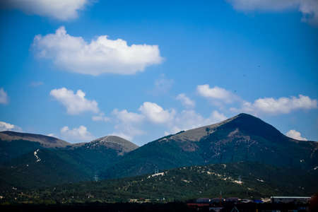 The lush greenery on the background of the blue sky with clouds in the beautiful mountains of the Krasnodar region of Russia.の写真素材