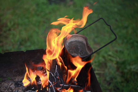 on burning coals is the tourist pot in which boiling water.