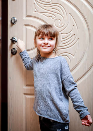 A little beautiful girl opens the door to the Playground of the house.の写真素材