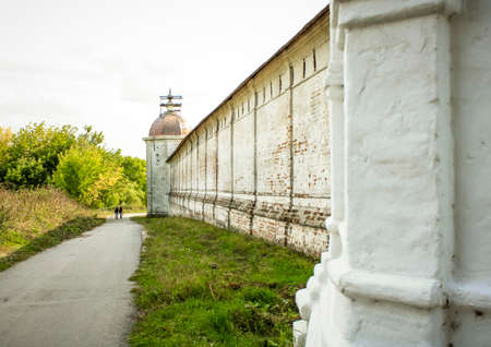 Fortress wall of the ancient Sven monastery in Russia, in Bryansk. Tourists walk along the road along the wall.の写真素材