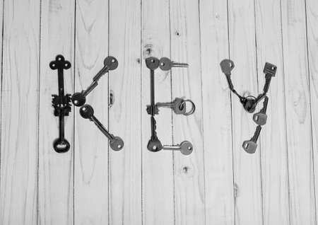 On the wooden table is a lot of old keys. They mean the word key.の写真素材