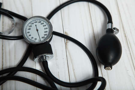 Hand-held device for measuring blood pressure on a wooden background.の写真素材