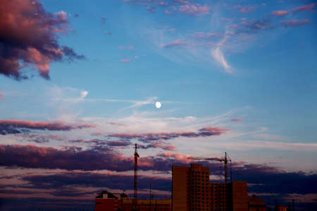 Construction of a high-rise building in the city at sunset.