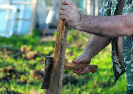 A man working in the garden. He cuts wood.の写真素材