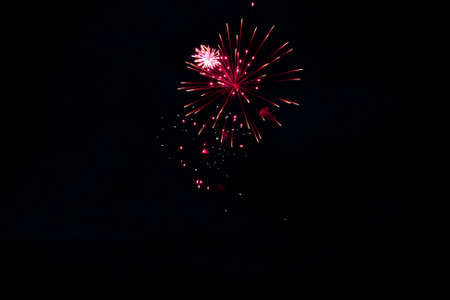 Red flashes of fireworks in the night sky.
