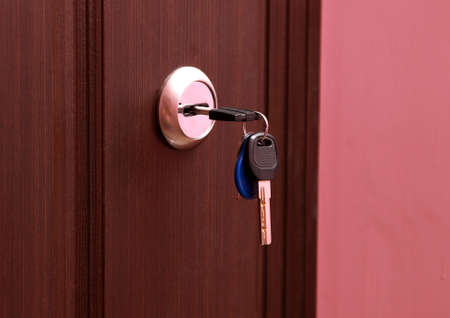 Close-up photography. The keys are in the keyhole of the front door.