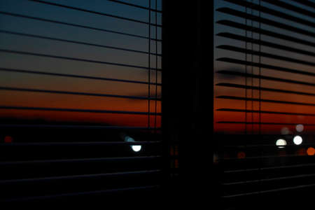 Through the open blinds you can see the evening sunset.の写真素材