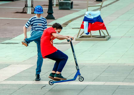 05 14 2019 Russia, Bryansk. Teenagers joke, ride on the city square on scooters.のeditorial素材