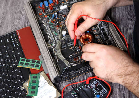 Electronics repair shops. Master is testing the transistors.