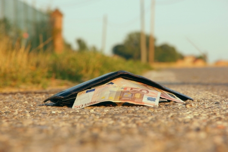lost wallet at the edge of a asphalted roadの写真素材