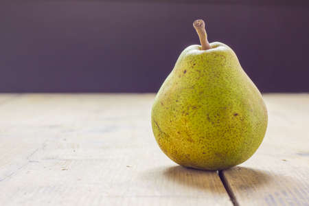 A pear on the table in front of a windowの写真素材