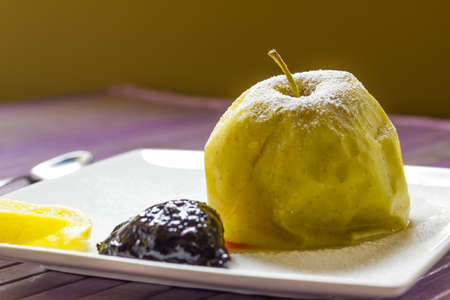 A plate with a baked apples and homemade plum jamの写真素材