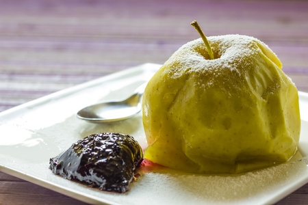 A plate with a baked apples and homemade plum jamの写真素材