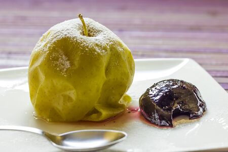 A plate with a baked apples and homemade plum jamの写真素材