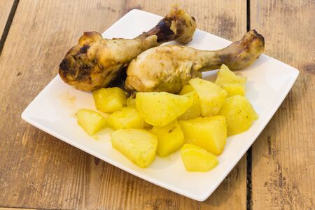 A plate of chicken legs with potatoesの写真素材