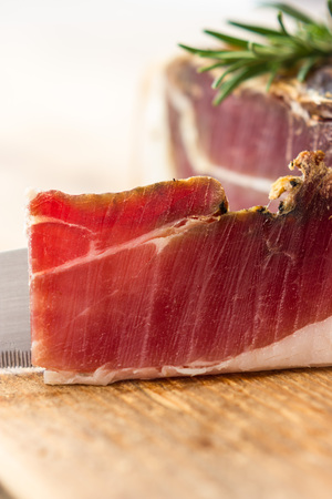 Tasty slices of Italian speck with rosemaryの写真素材