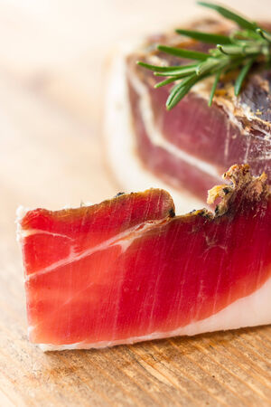 Tasty slices of Italian speck with rosemaryの写真素材
