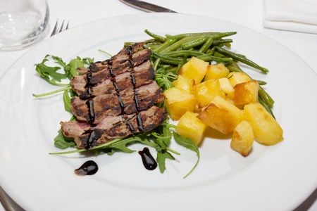 Sliced beef with balsamic vinegar and roasted potatoesの写真素材