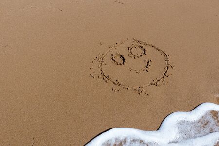 Smile draw on the shore of the seaの写真素材