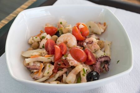 Fish salad with tomatoes and olivesの写真素材