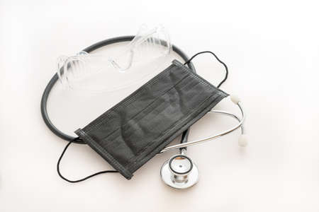 Covid-19 mask, stethoscope and glasses on whiteの写真素材