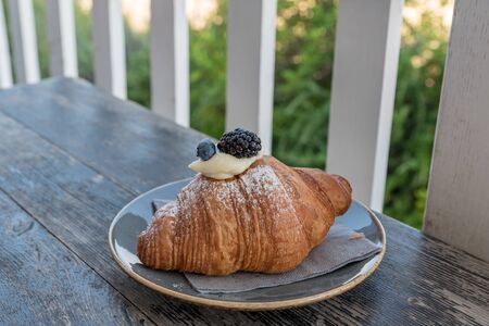 Croissants with blackberries and blueberries filled with creamの写真素材