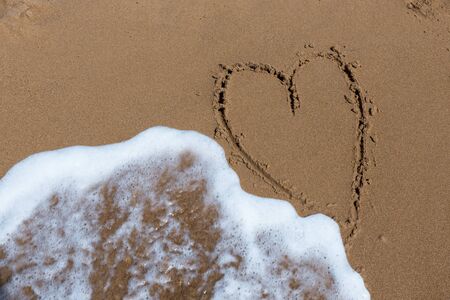Heart draw on the shore of the seaの写真素材