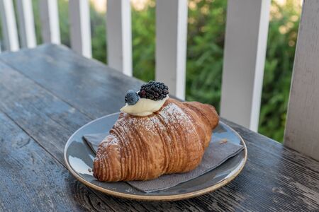 Croissants with blackberries and blueberries filled with creamの写真素材