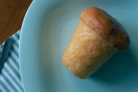 Neapolitan Baba with rum as desserton on a blue plate as Naples symbols