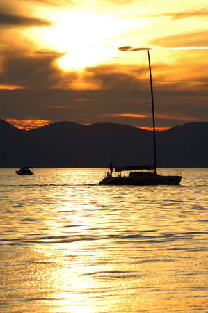 Boat sailing in the evening at sunsetの写真素材