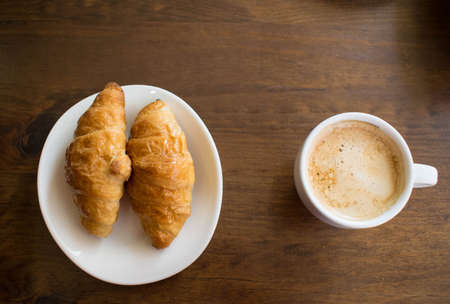 Delicious breakfast in the morning of chocolate curasanes with coffee with milkの写真素材