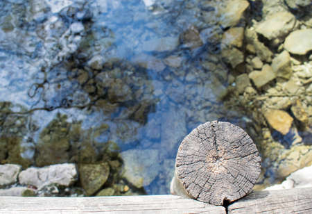 Wooden bridge over a lake of clear water on a sunny dayの写真素材